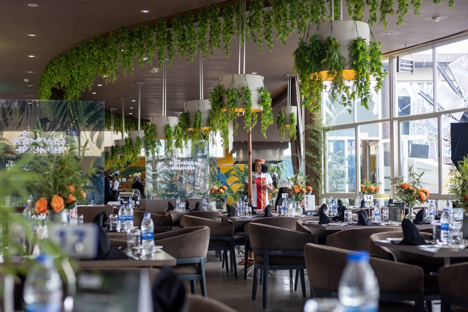 The Kampala Brunch dining room with hanging greenery and branded glass signage, September 2024