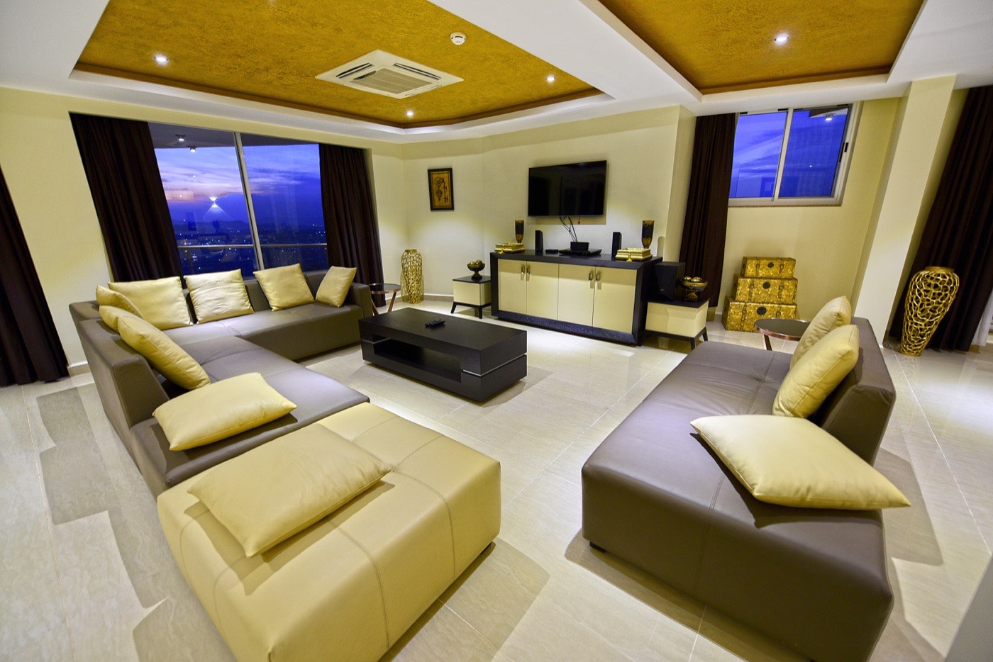 Presidential Suite living room with gold ceiling accents and night city views